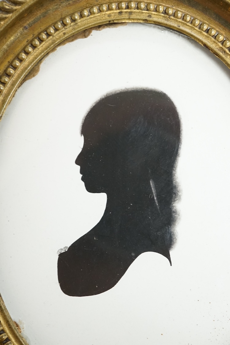 Mrs Mary Lightfoot (18th. C), oval painted silhouette portrait of a young lady, on plaster, printed trade label verso, embossed brass frame, overall 12cm high